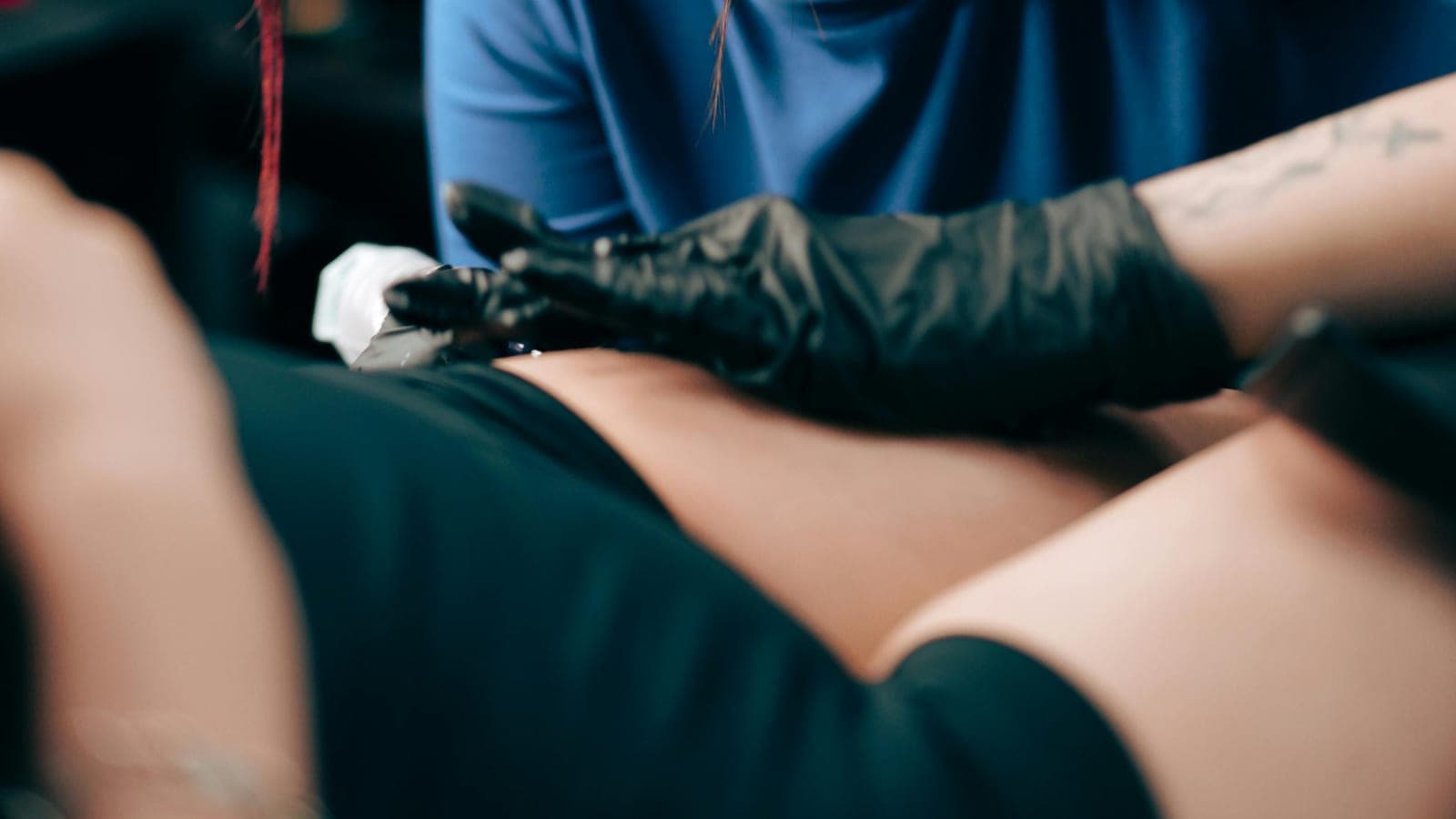 Tatuadora concentrada a trabalhar no estúdio