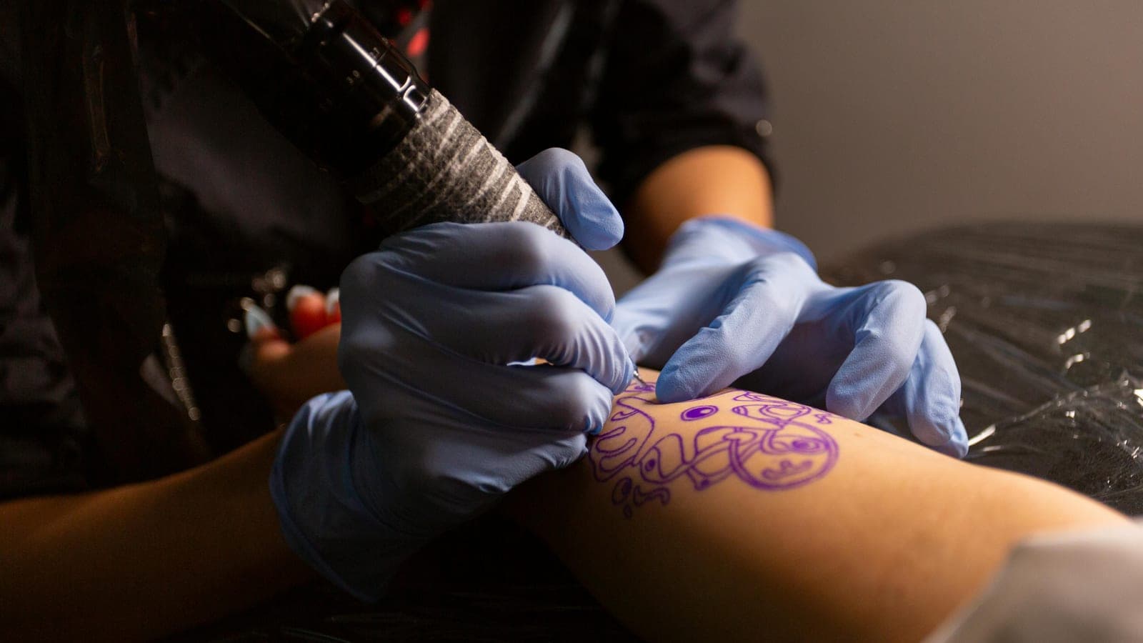 A fine-line tattoo being worked on a client's wrist