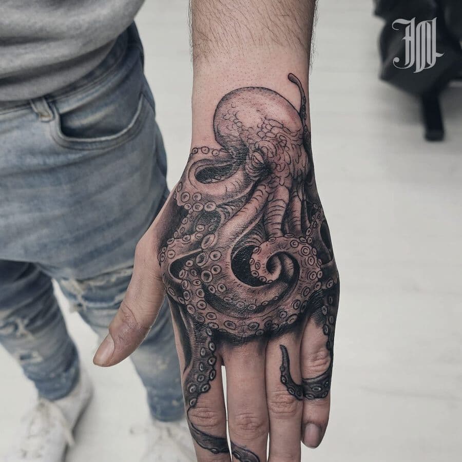 Black and grey octopus tattoo on a hand, from the Aura Tattoo & Meaning gallery